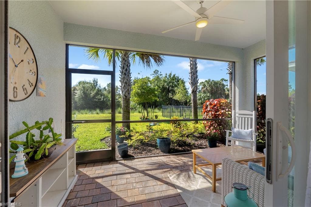 Screened lanai with a ceiling fan, brick-finish flooring, and built-in shelving
