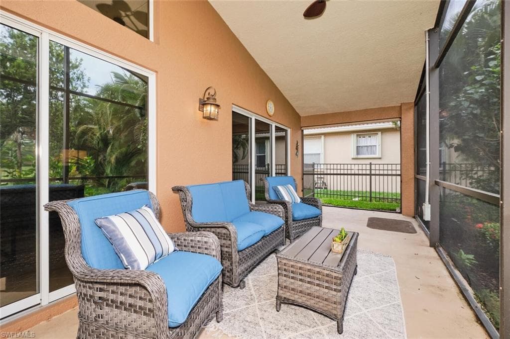 Covered patio featuring a ceiling fan, screened enclosure, and exterior wall lantern