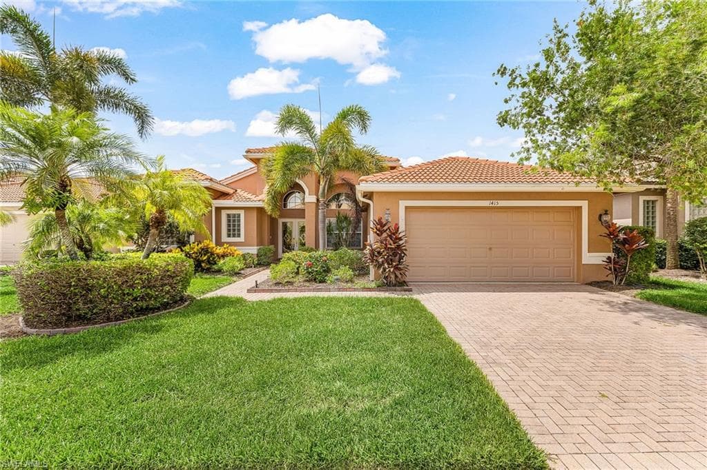 Stucco exterior with a tile roof, arched entryway, and a two-car garage