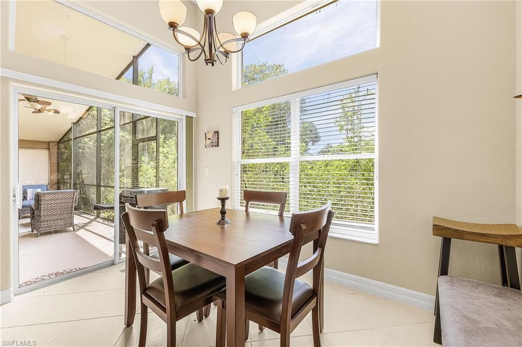 Vaulted ceilings with clerestory windows, screened patio with ceiling fan, sliding glass doors, and tile flooring