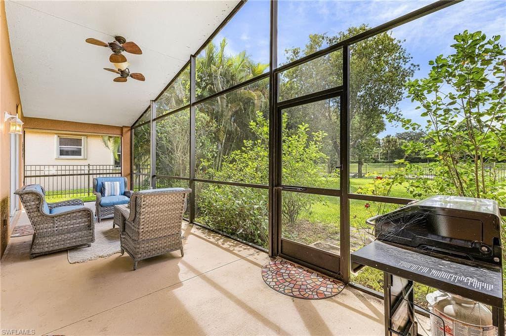 Screened patio featuring a solid concrete floor and multiple ceiling fans