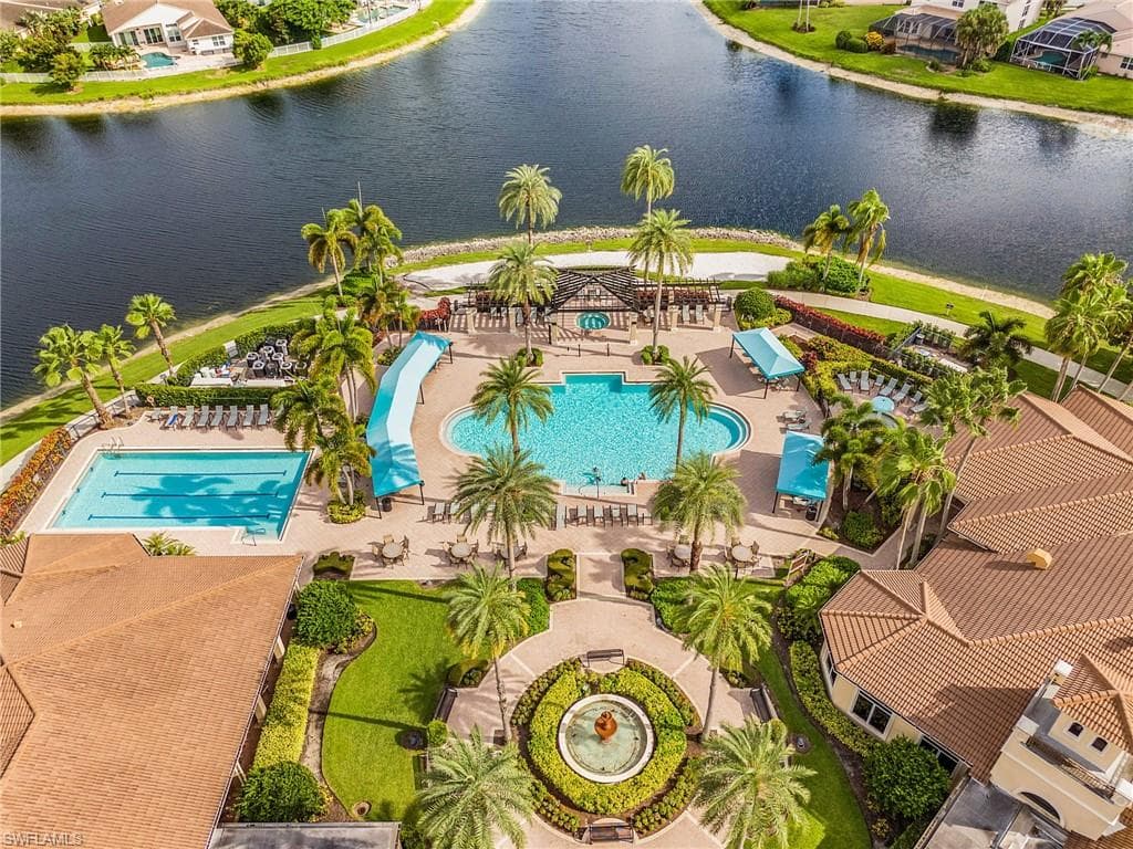 Expansive aquatic facility featuring a resort-style pool with a waterslide, a lap pool, and a large central fountain