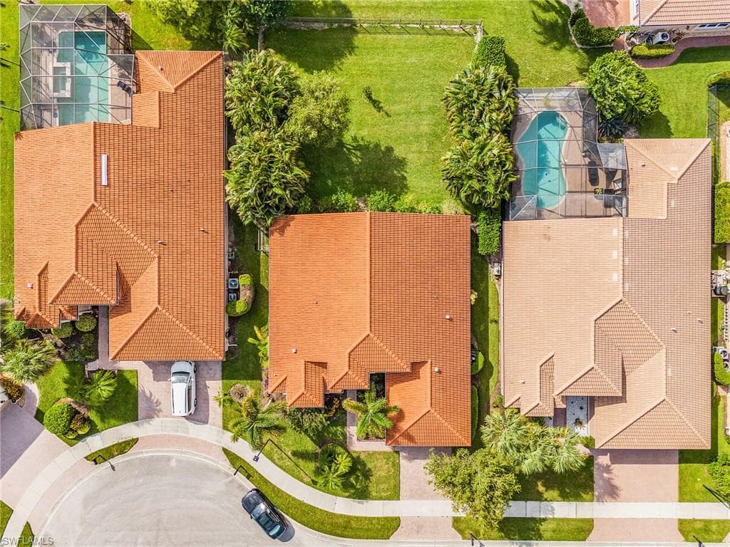 Tile roofing, screened pool enclosure, mature landscaping, circular driveway, and a cul-de-sac location