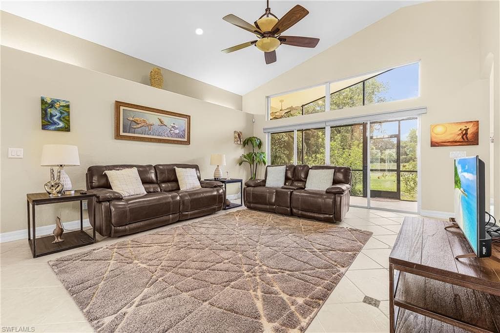Vaulted ceiling with a ceiling fan, recessed lighting, and a transom window