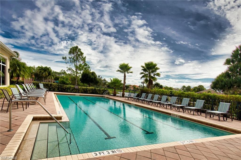 Rectangular swimming pool with lane markers, integrated entry steps, and a surrounding paver deck