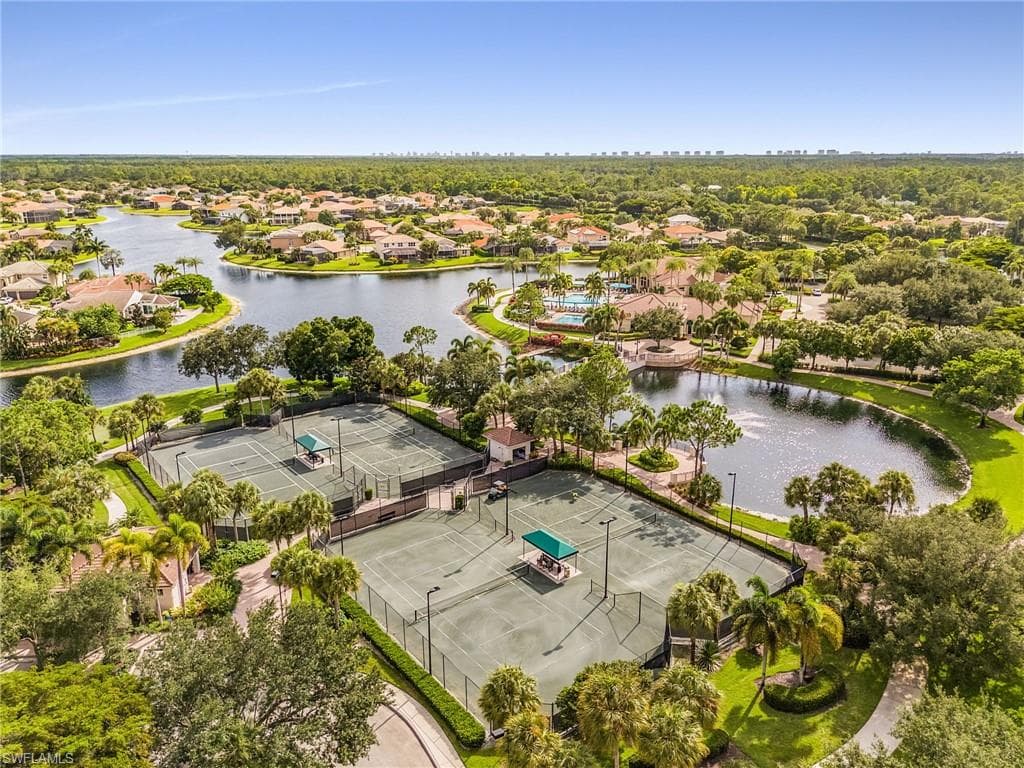 Expansive neighborhood with multiple tennis courts, surrounding water features, and lush landscaping