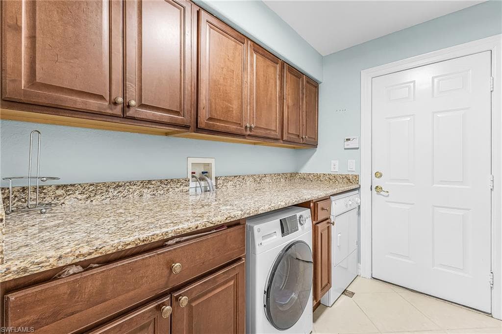 Laundry area featuring wood-finish cabinetry, light-toned countertops, and light blue wall color