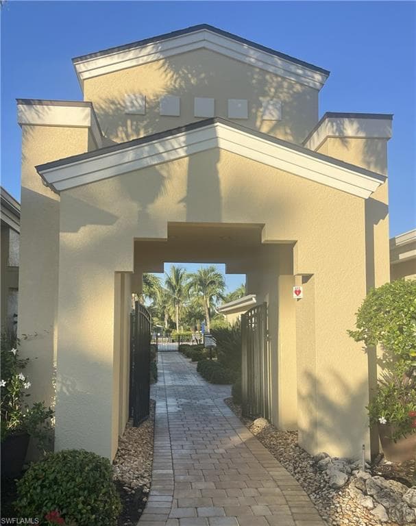Property entrance with a gate and stucco siding