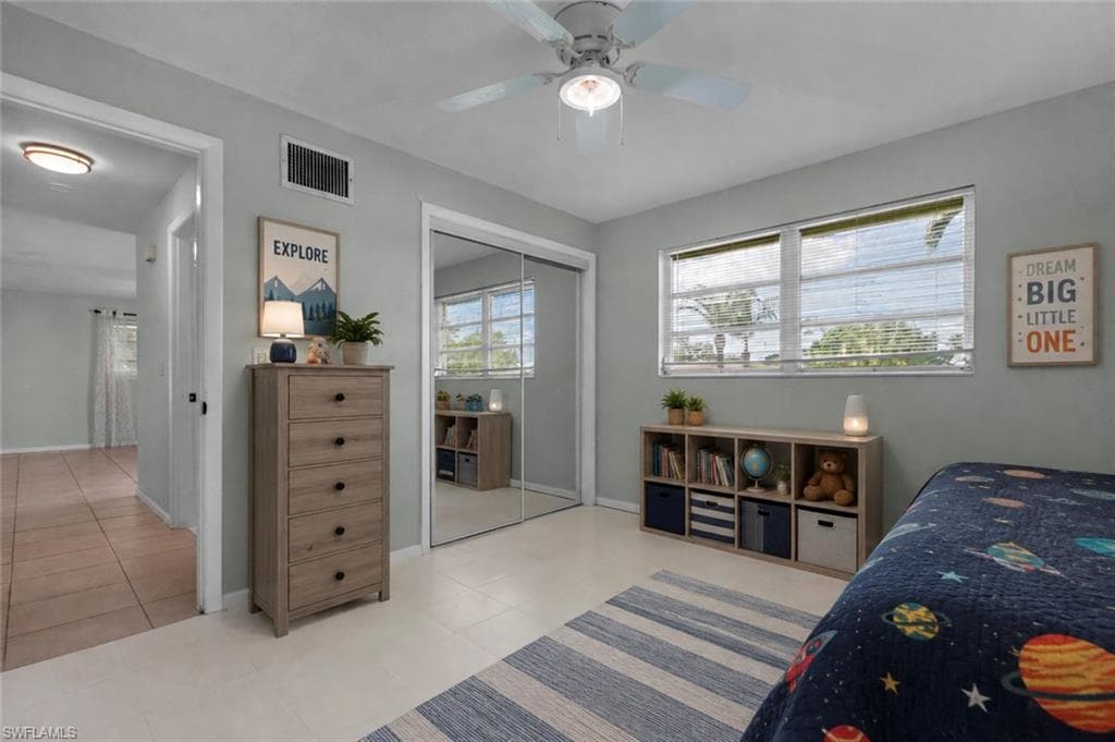 Recessed lighting, ceiling fan, mirrored closet doors, and large windows