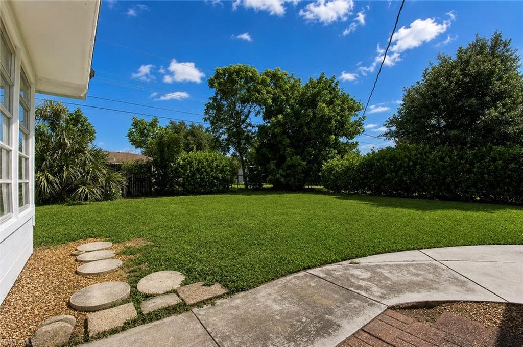 Expansive lawn area with mature trees and established perimeter shrubs