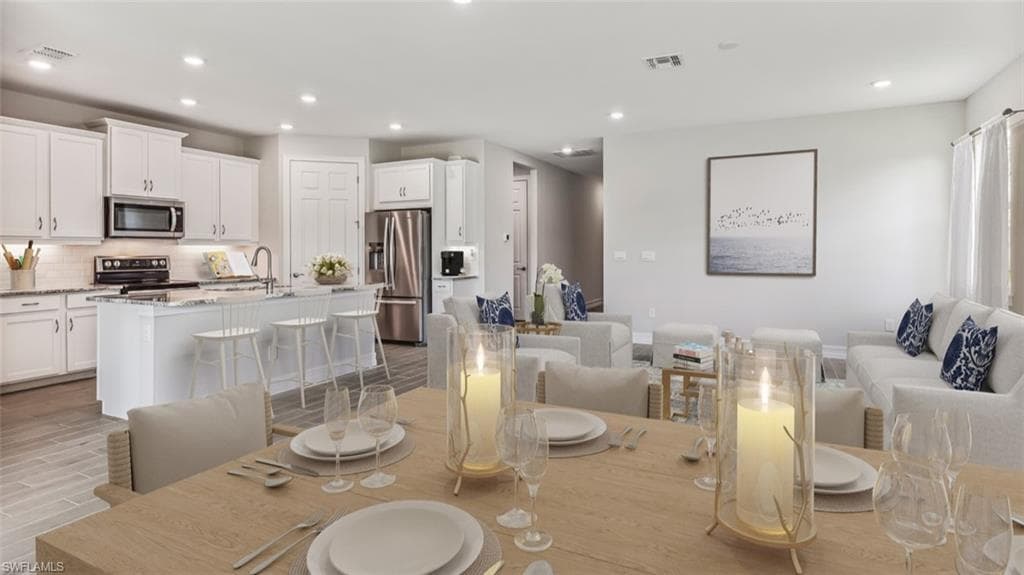 This image is virtually staged. Dining space featuring recessed lighting and light wood-style floors