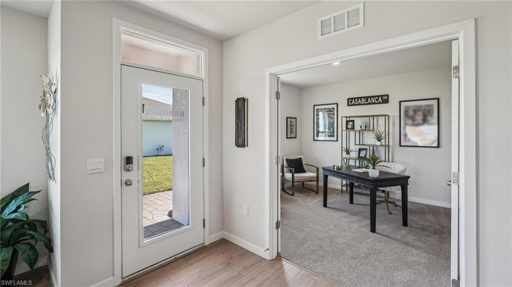 Foyer with wood-finish flooring and a glass-paneled entry door with transom