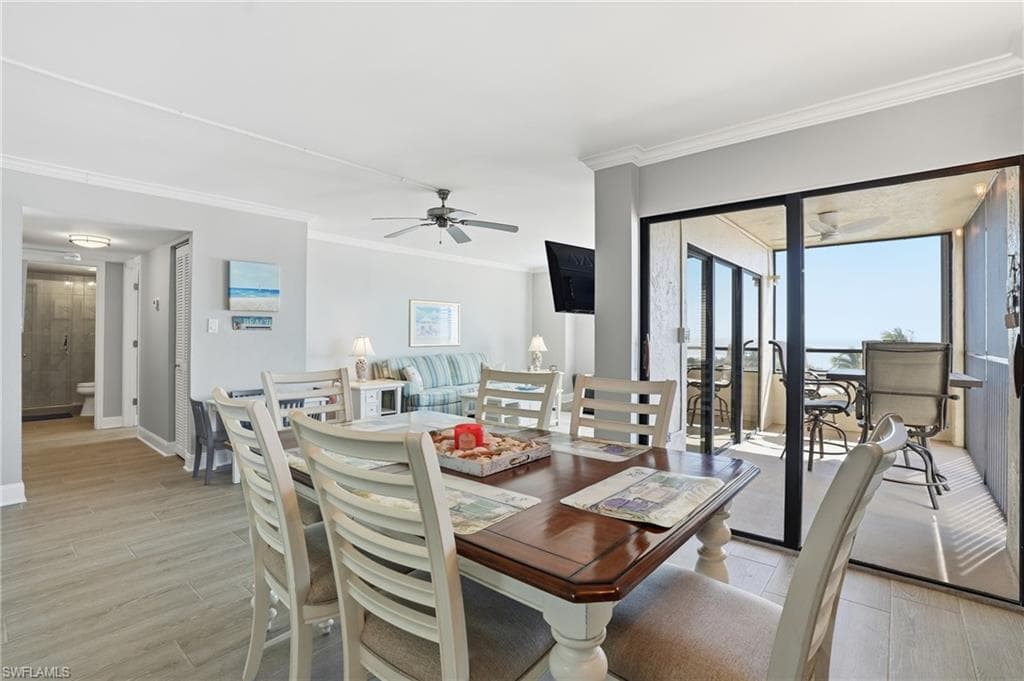 Dining space featuring light wood-style floors, ornamental molding, and ceiling fan