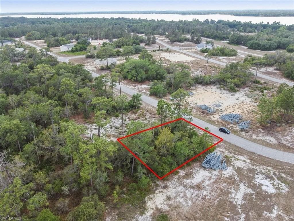 Wooded lot with mature trees, paved road frontage, and substantial undeveloped land