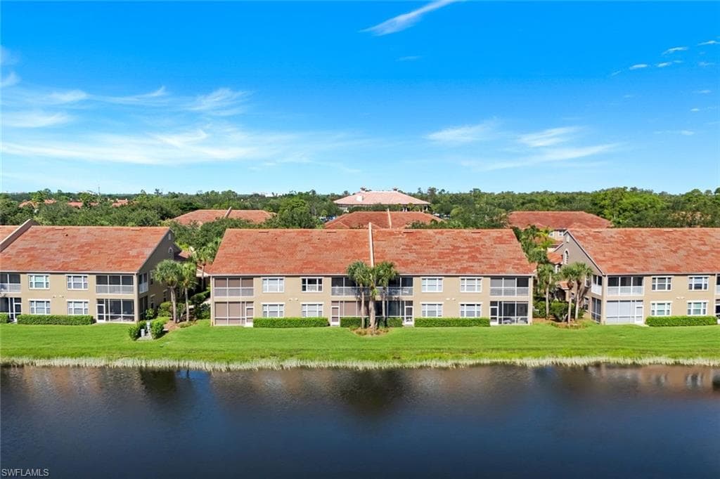 Community buildings featuring tile roofing and multiple screened balconies overlooking a body of water