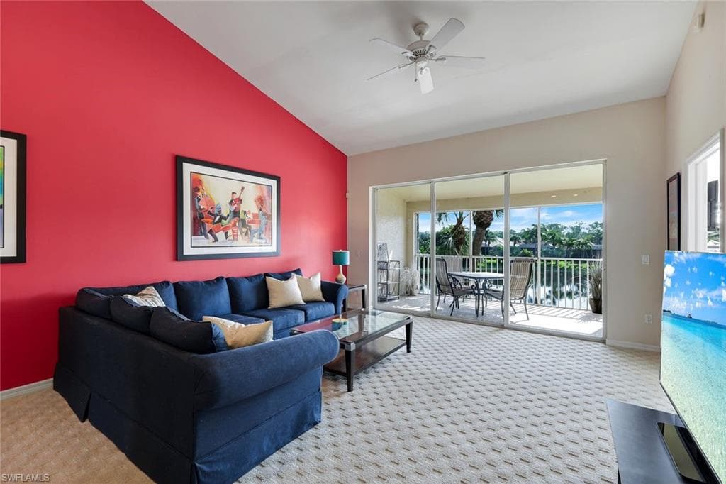Spacious Great Room with Vaulted Ceiling, Ceiling Fan, and Sliding Glass Doors Opening to an East-Facing Screened Lanai