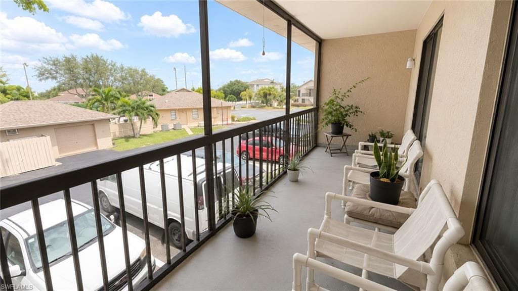 Screened balcony with textured exterior walls and a painted concrete floor