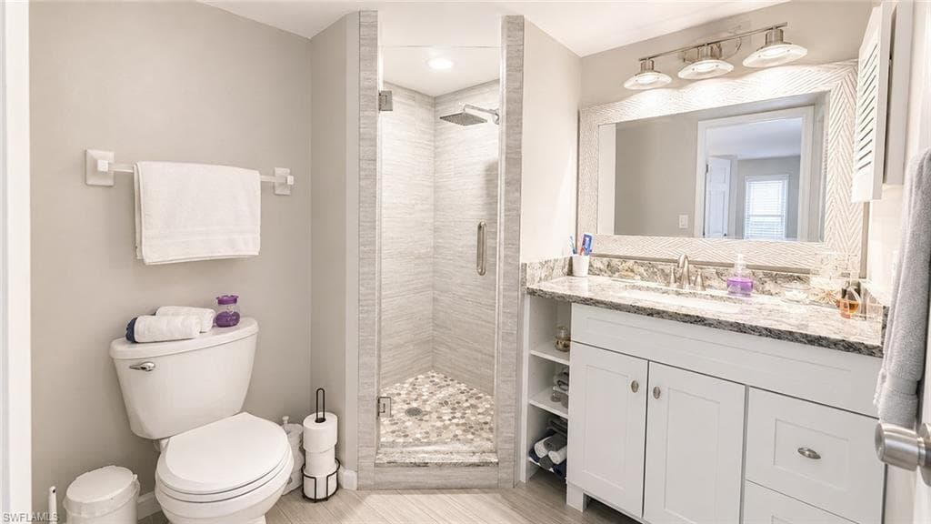 Glass-enclosed shower with a pebble floor and tiled walls
