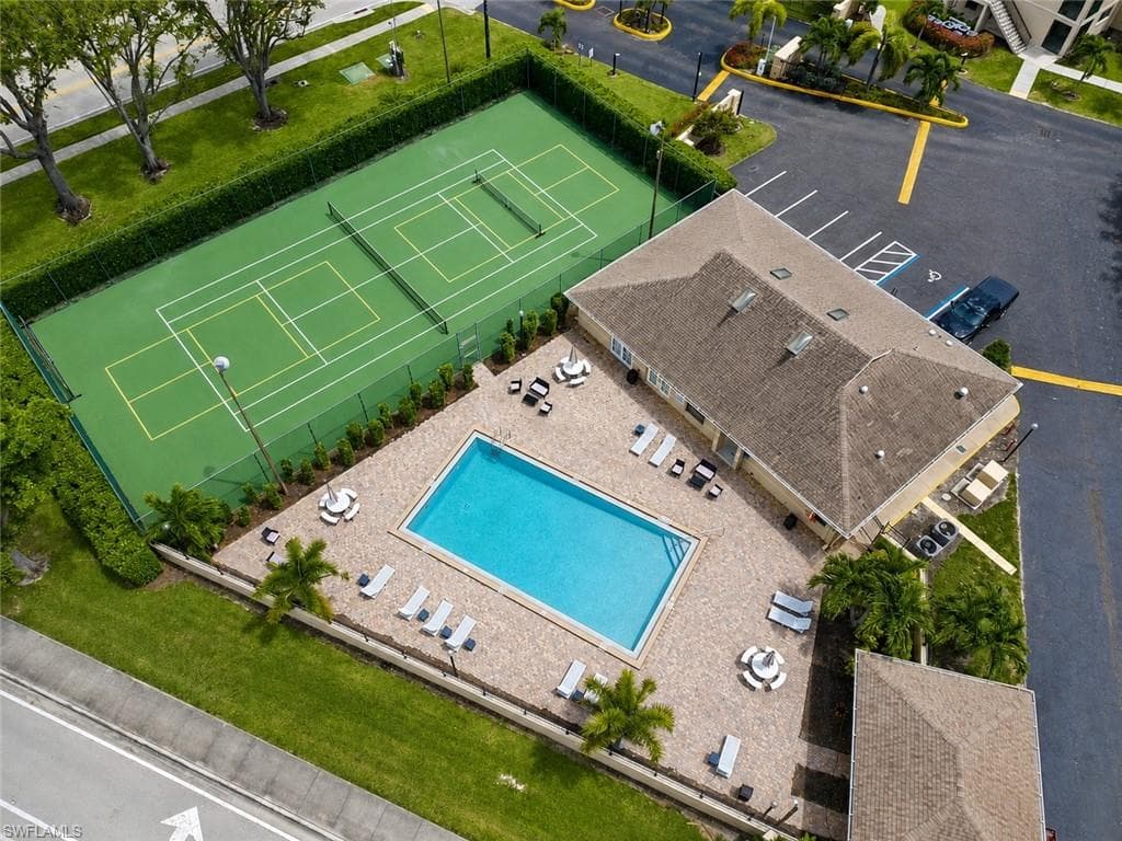 Recreational amenities featuring a tennis court, swimming pool, and paver deck