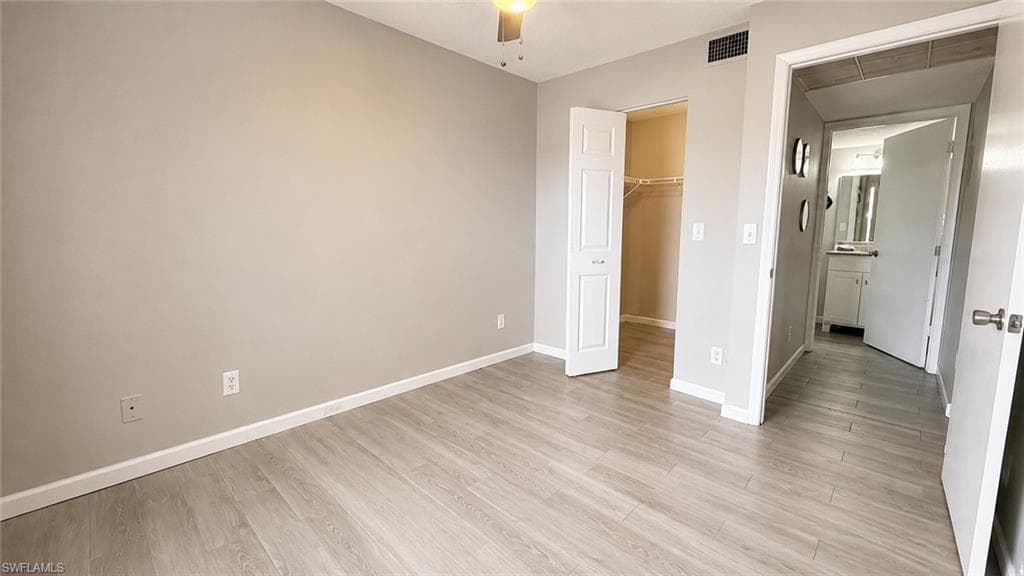 Neutral wall color, wood-finish flooring, ceiling fan, bi-fold closet doors, built-in shelving