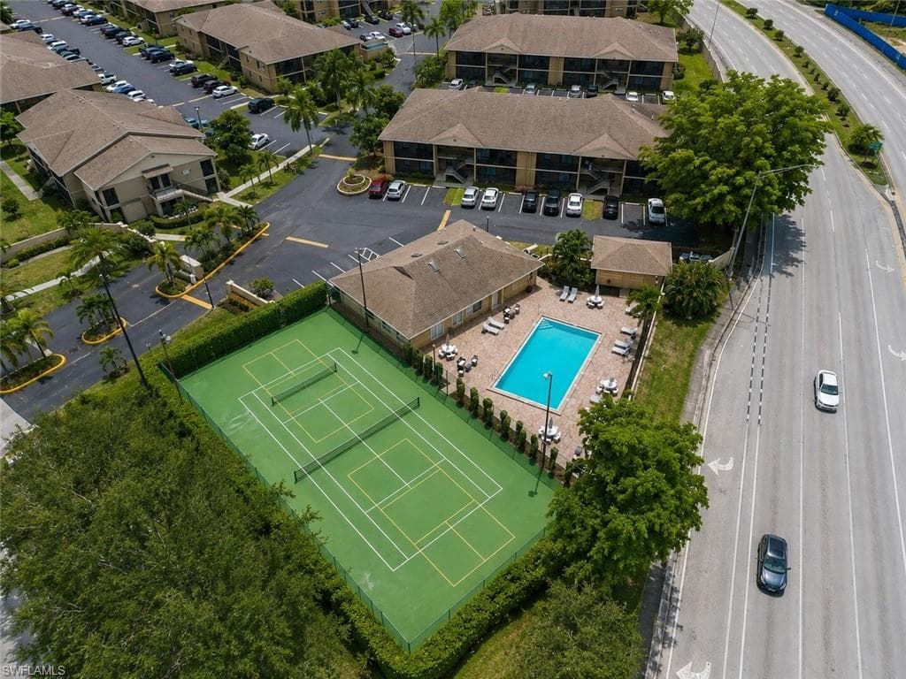 Community amenities featuring a tennis court, rectangular swimming pool, and dedicated parking areas