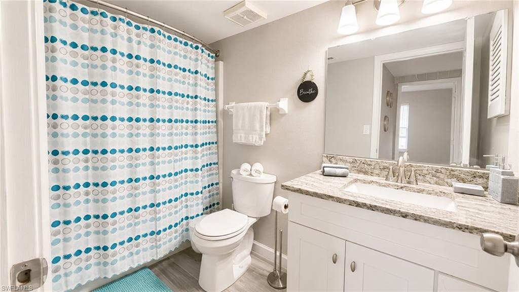 White vanity with a light-colored countertop, undermount sink, and brushed nickel faucet