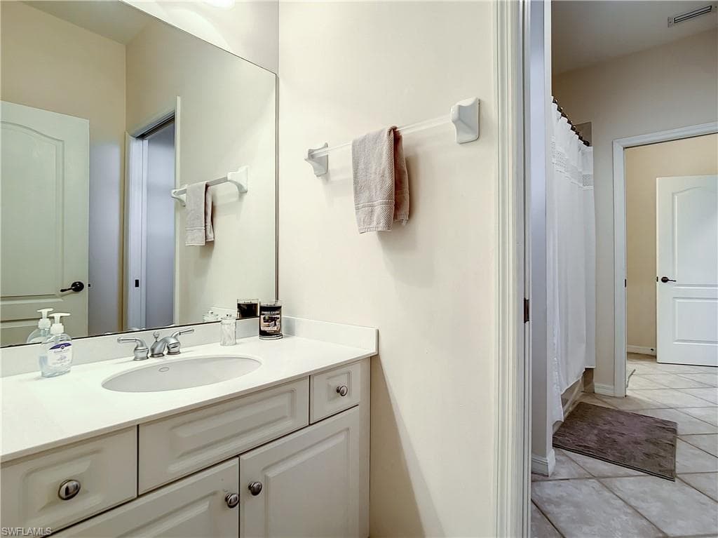 White vanity with an integrated sink, polished chrome faucet, and expansive wall-mounted mirror