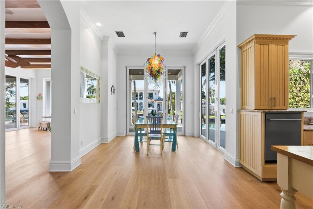 Light wood-finish flooring throughout, crown molding, recessed lighting, and expansive glass paneled doors