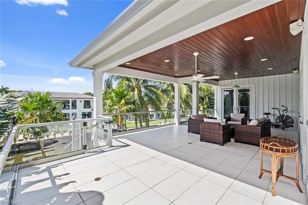 Expansive covered patio featuring a wood-finish ceiling, recessed lighting, and ceiling fans