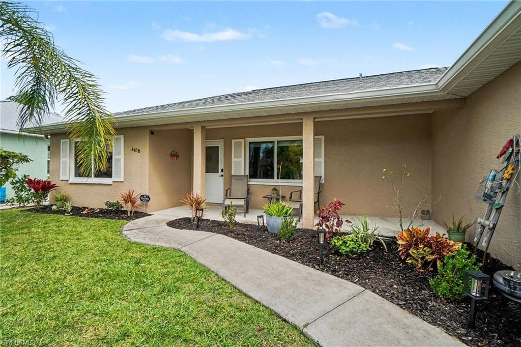 Front elevation with light tan stucco finish and a covered entry