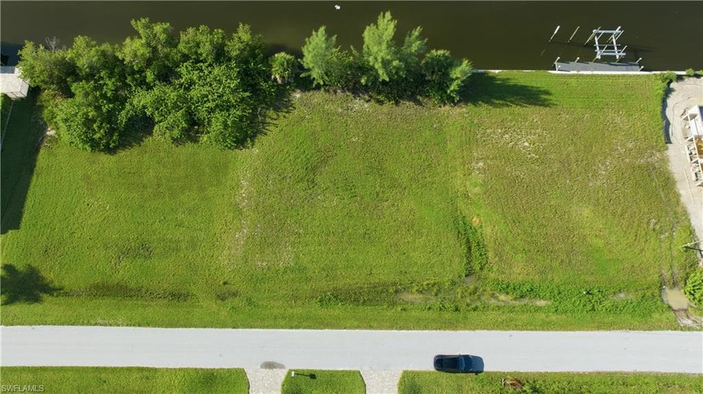 Expansive lot with canal frontage, mature trees, and a paved street
