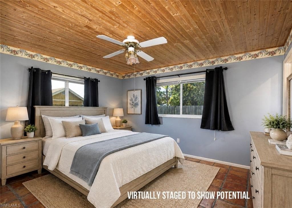 VIRTUALLY STAGED Wood-paneled ceiling with ceiling fan, multiple windows with dark drapery, light blue painted walls, and terracotta-style flooring