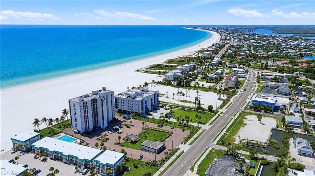 Coastal property with direct beach access, multi-story buildings, and an on-site swimming poolExpansive land parcel with direct beach access, surrounded by established buildings and roadways - Virtually Edited Image