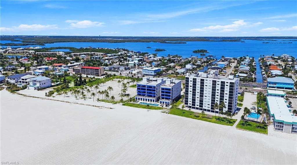Expansive beachfront property featuring direct beach access, multiple high-rise buildings, an outdoor swimming pool, and proximity to waterways - Virtually Edited Image