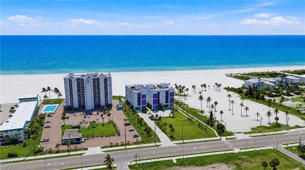 Expansive land parcel with direct beach access, surrounded by established buildings and roadways - Virtually Edited Image