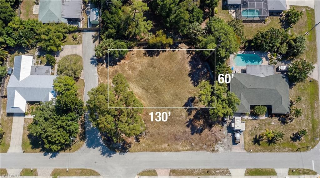Aerial view of property and surrounding area featuring property boundaries highlighted and a pool area