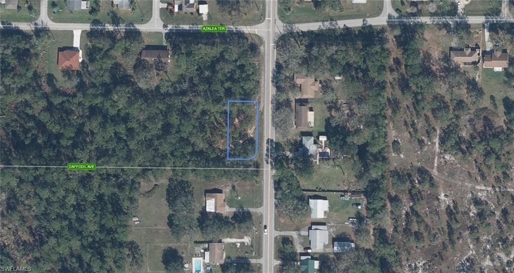 Aerial View. Depicting the property outlined in blue, surrounded by other land parcels and roads