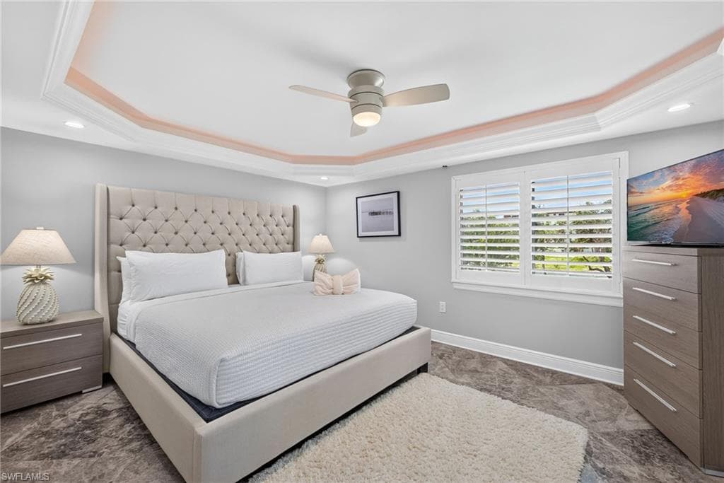 Primary bedroom with tray ceiling and crown