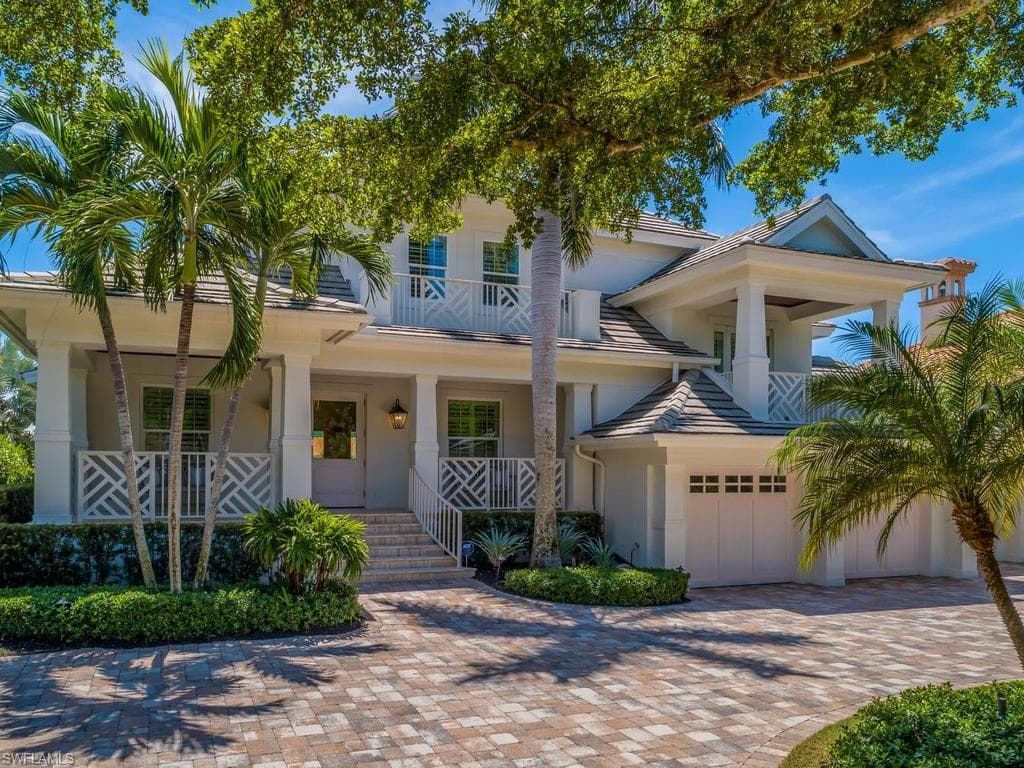 A palm lined circle drive; an inviting porch - a fantastic location. Welcome home to your boathouse!