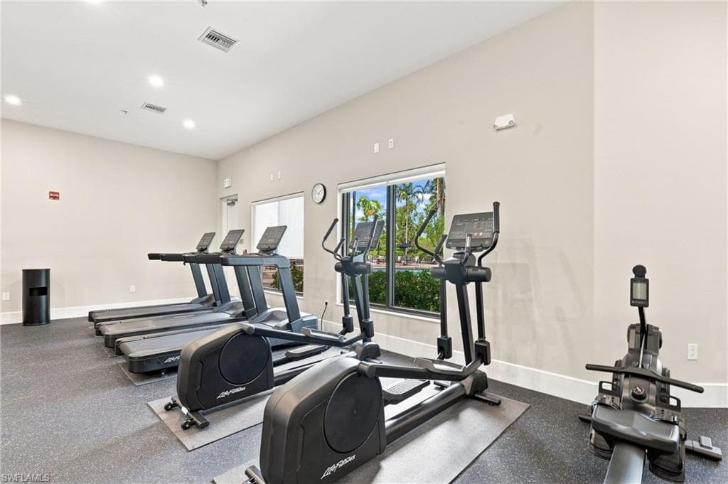 Fitness area featuring multiple exercise machines, recessed ceiling lighting, and large windows
