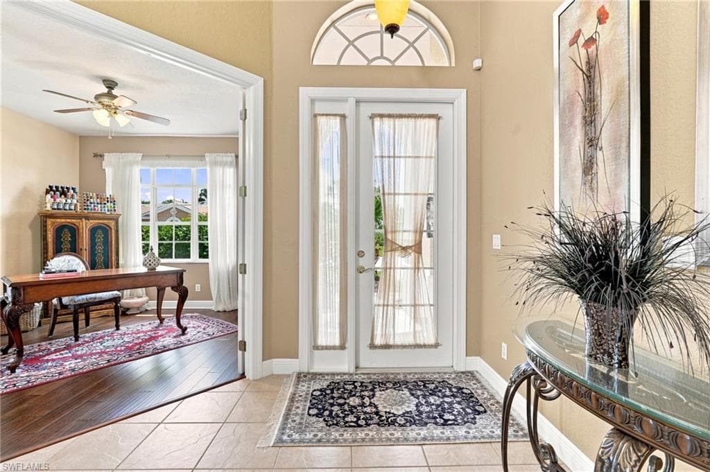 Tiled entryway with an arched transom window and double doors