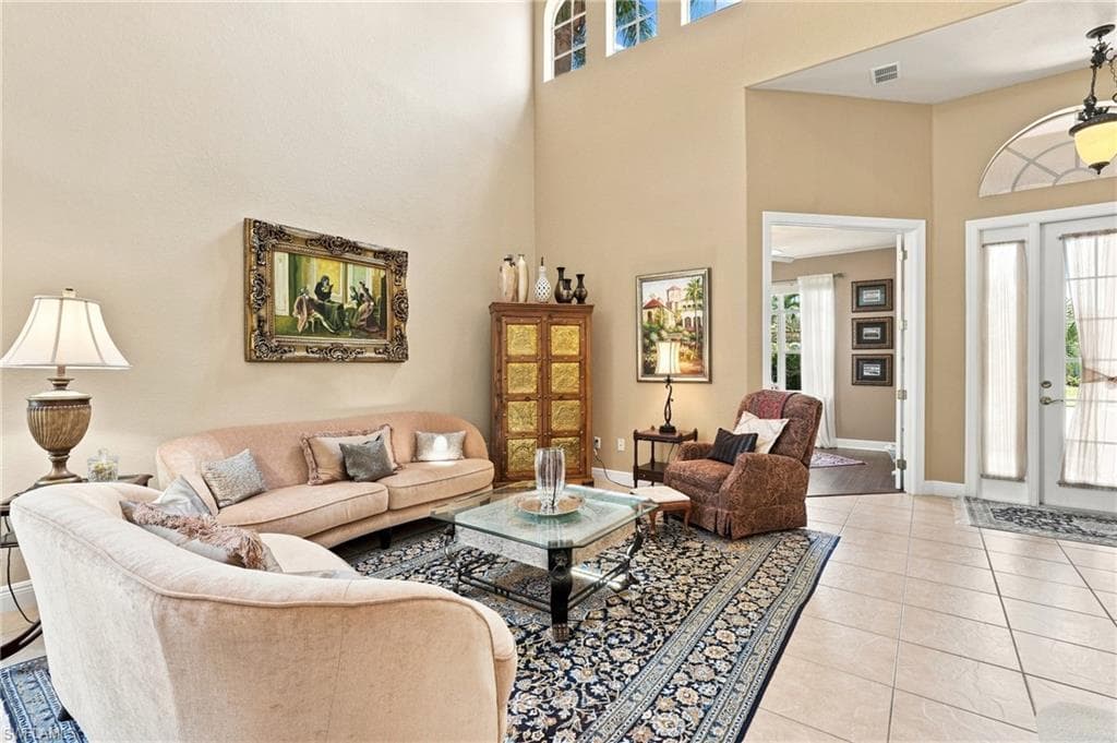 Vaulted ceilings, transom window, and French doors complement the tiled flooring