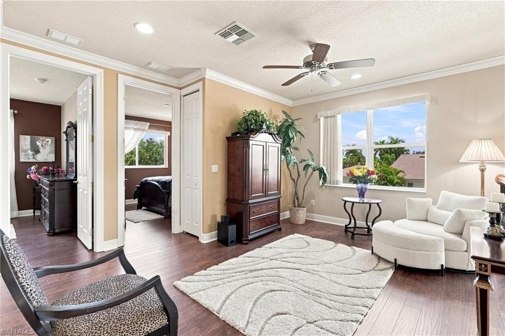Wood-finish flooring throughout, tray ceiling with recessed lighting, and a ceiling fan