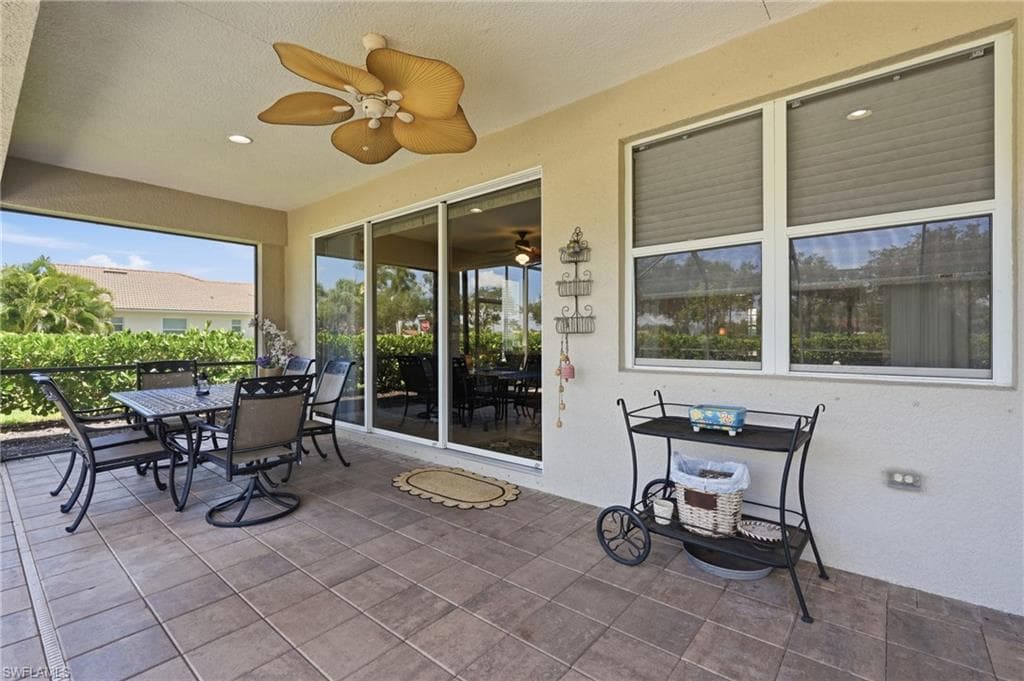 Screened lanai featuring tile flooring, ceiling fan, and sliding glass doors