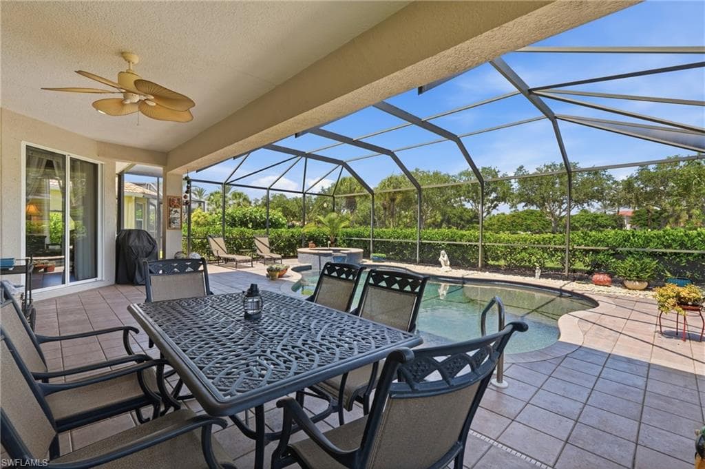 Screened patio with a built-in pool, ceiling fan, and tiled flooring