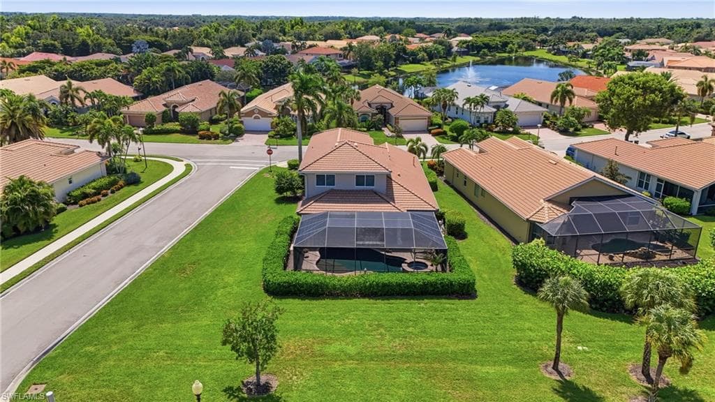 Aerial perspective of a neighborhood featuring residential structures with tile roofs and manicured landscaping