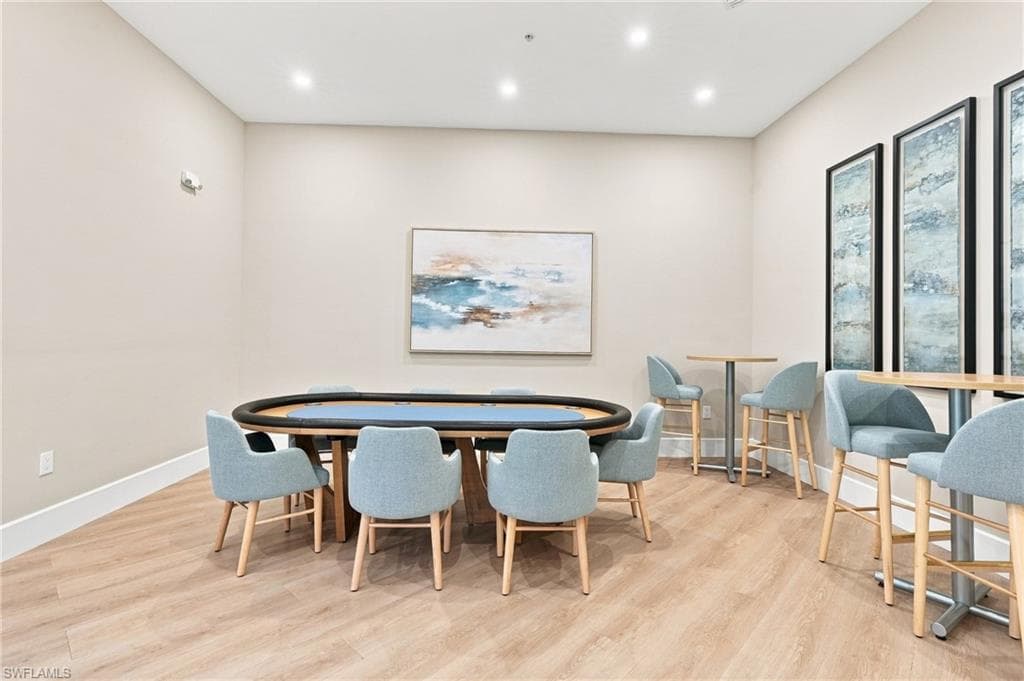 Recessed ceiling lighting, light wood-finish flooring, and neutral wall paint create a bright interior
