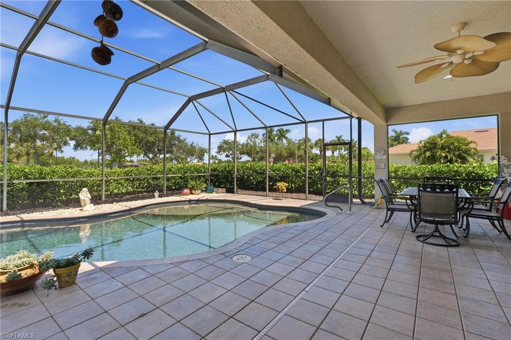 Screened lanai with an in-ground swimming pool, tiled patio, and a ceiling fan
