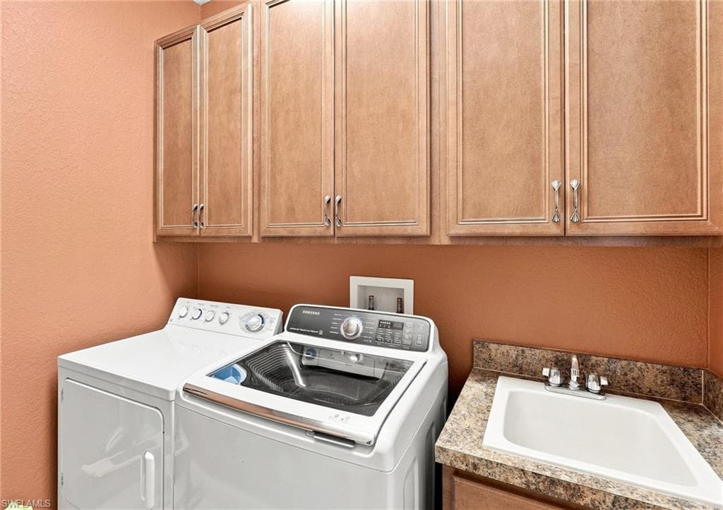 Upper cabinetry with panel doors, laminate countertop with integrated sink, and chrome faucet