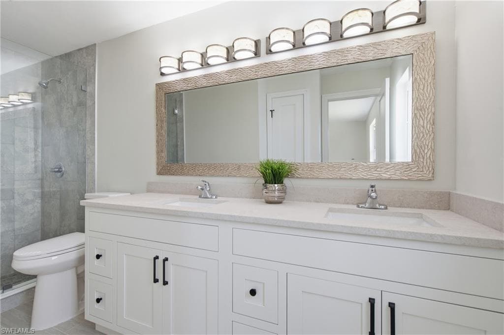 His and her sink with beautiful mirror, light fixture, and gorgeous new shower.